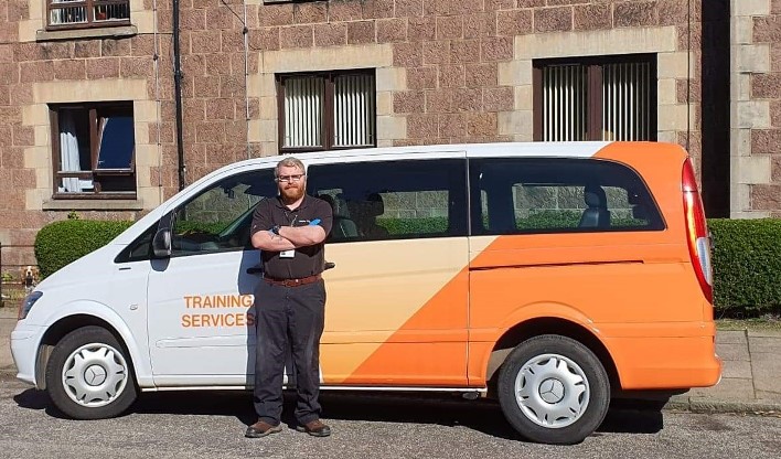 Survival and Marine Instructor beside Petrofac van used for volunteer deliveries